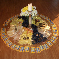 A mandala made as the centrepiece at one of the days in the Creative Chakra Connection course. Made with candles, flowers, yellow and indigo scarfs and other ornaments it represents the Solarplexus and 3rd-eye chakras.