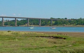 Orwell bridge over the river Orwell with boats at moorings. The beautiful rivers of Suffolk connect with Cathie's previous experience as a sailor and the drive over this bridge to her Holbrook class on Mondays. Bridge and Boat are both yoga postures.