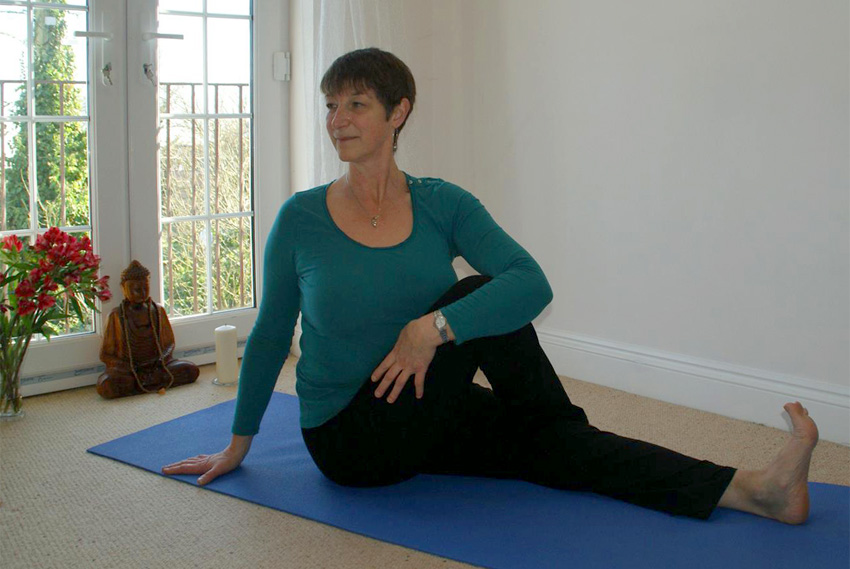 Cathie in seated twist in her teaching space. This releases the spine, opens the heart and chest area and is very grounding.